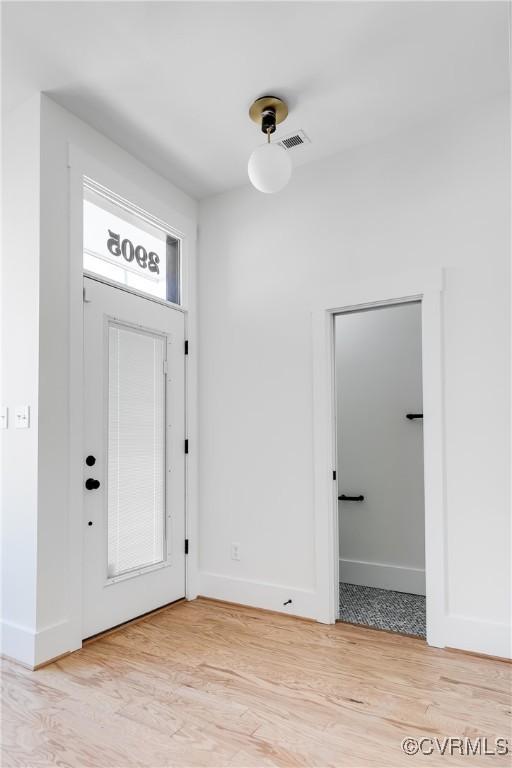 entryway featuring light wood finished floors, visible vents, and baseboards