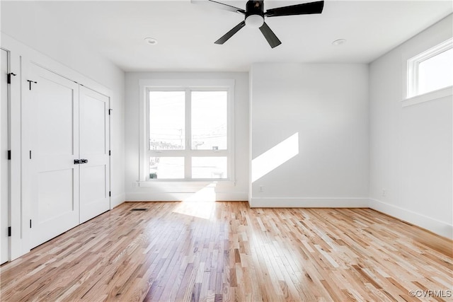 unfurnished bedroom with light wood-style floors, baseboards, and a ceiling fan