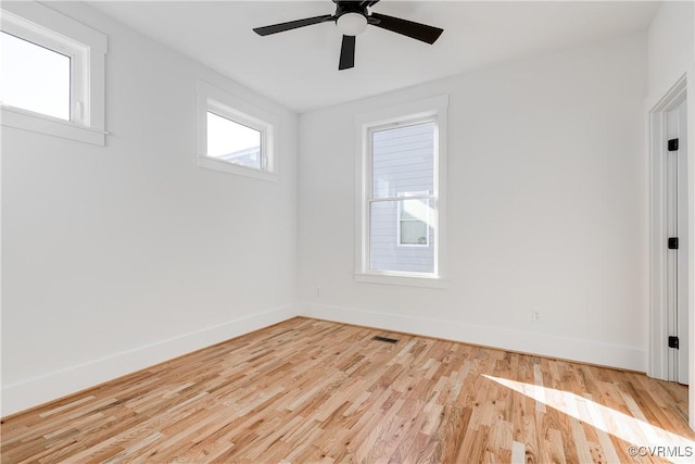 unfurnished room featuring ceiling fan, baseboards, visible vents, and wood finished floors