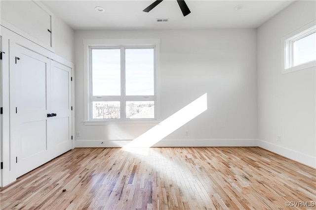interior space featuring visible vents, baseboards, a ceiling fan, and wood finished floors