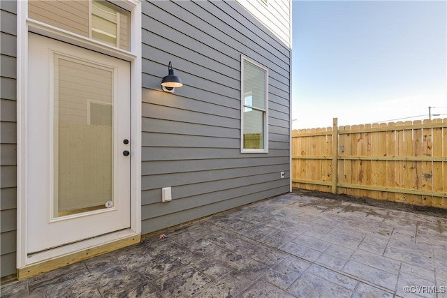 property entrance with a patio area and fence