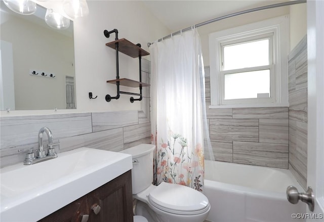 full bath with toilet, tile walls, shower / tub combo, and vanity