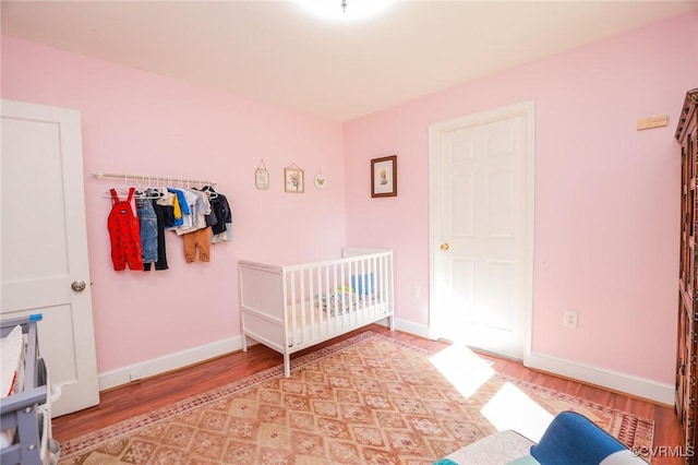 bedroom with baseboards and light wood finished floors