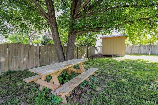 view of yard featuring an outdoor structure, a fenced backyard, and a storage shed