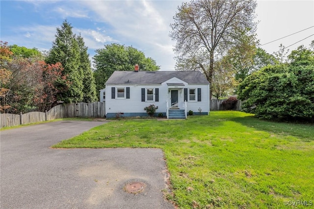 bungalow featuring fence, driveway, and a front yard