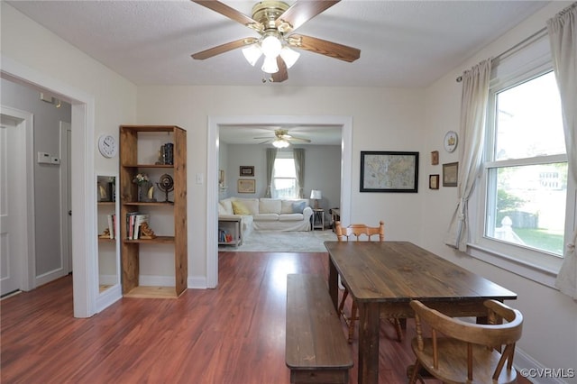 dining space featuring baseboards, a ceiling fan, and wood finished floors