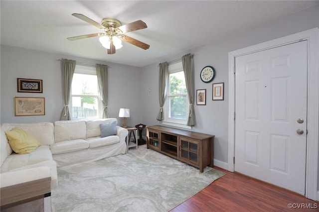 living area with plenty of natural light, ceiling fan, and wood finished floors
