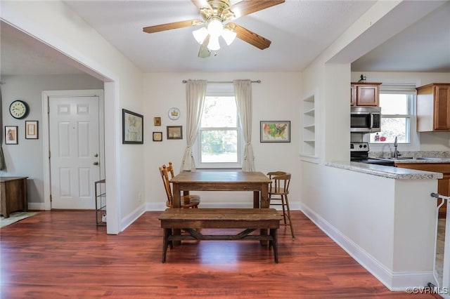 dining space with baseboards, a ceiling fan, and dark wood-style floors