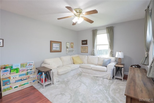 living area with ceiling fan and wood finished floors
