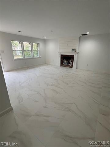 233 Christopher Wren Rd, Williamsburg, VA 23185 - unfurnished living room featuring light marble finish floors, baseboards, and a fireplace