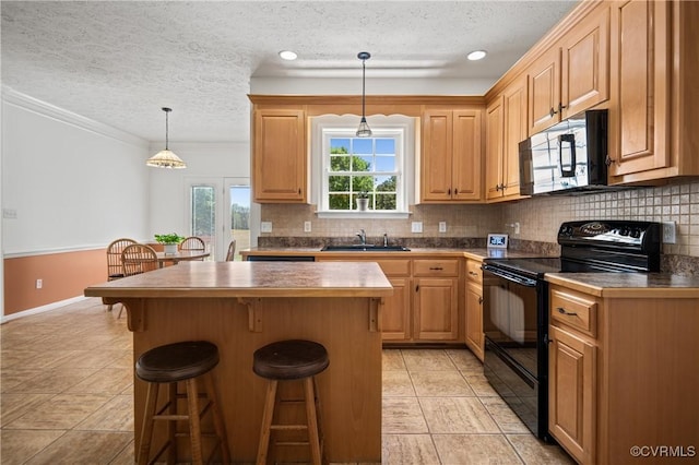 kitchen with a textured ceiling, a sink, stainless steel microwave, electric range, and a breakfast bar