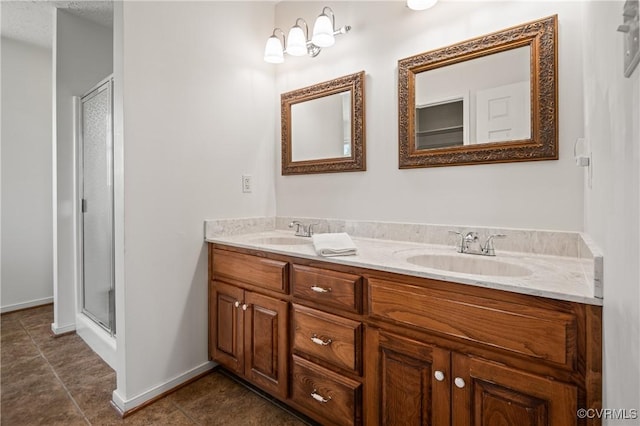 full bathroom with double vanity, a shower stall, tile patterned floors, and a sink