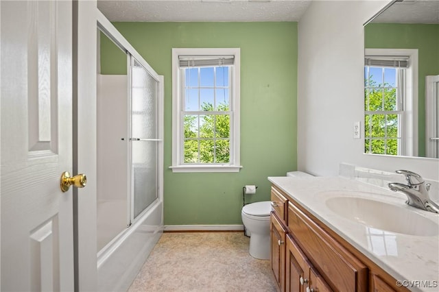 full bathroom featuring baseboards, a healthy amount of sunlight, toilet, and vanity