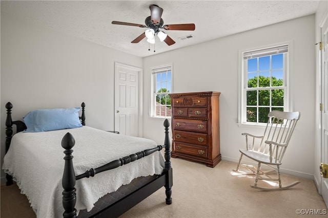 bedroom with baseboards, visible vents, light colored carpet, and multiple windows