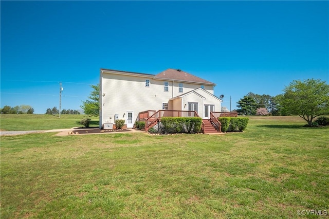 back of property featuring a yard, a deck, and stairs
