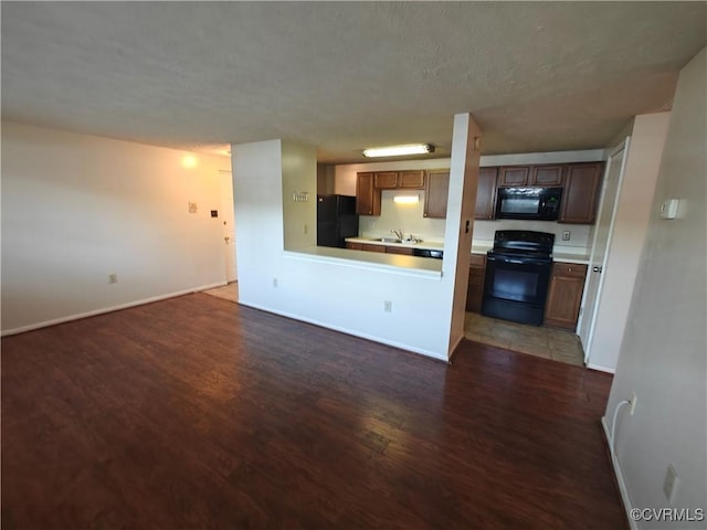 interior space with a sink, baseboards, and wood finished floors
