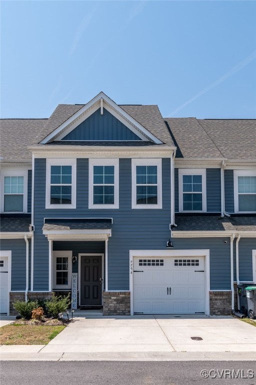view of front of property featuring an attached garage, a shingled roof, board and batten siding, and concrete driveway