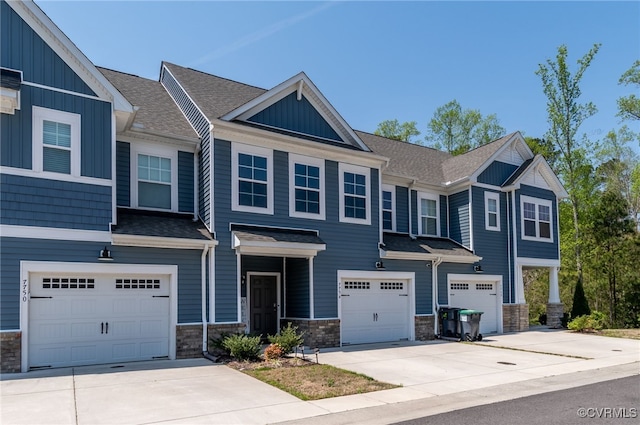 multi unit property featuring board and batten siding, stone siding, and a garage