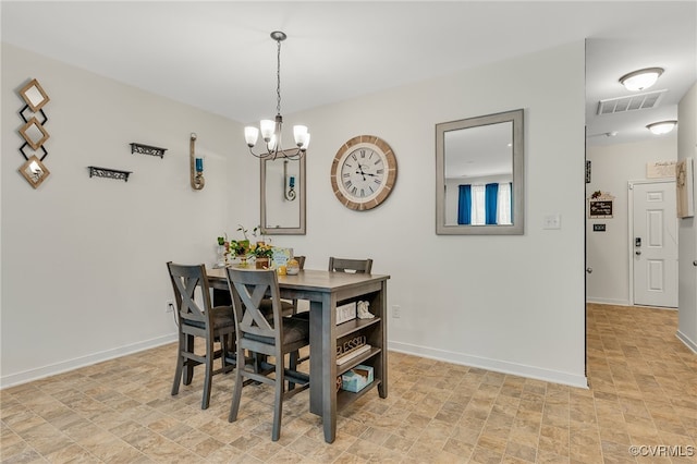 dining area with visible vents, baseboards, a chandelier, and stone finish flooring