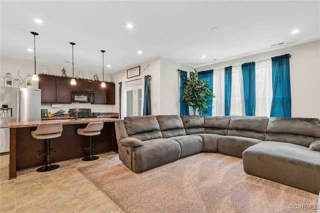 living area featuring recessed lighting and visible vents