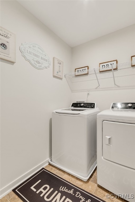 washroom with separate washer and dryer, laundry area, baseboards, and light tile patterned flooring