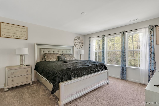 carpeted bedroom featuring visible vents and baseboards