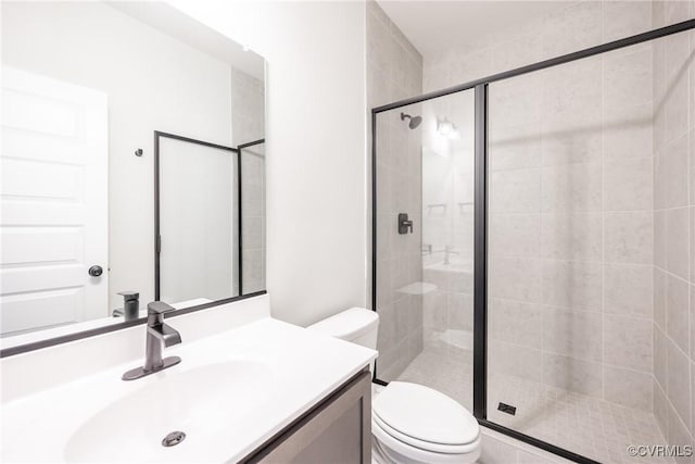 bathroom with toilet, a stall shower, and vanity