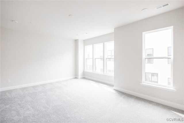 carpeted empty room featuring visible vents and baseboards