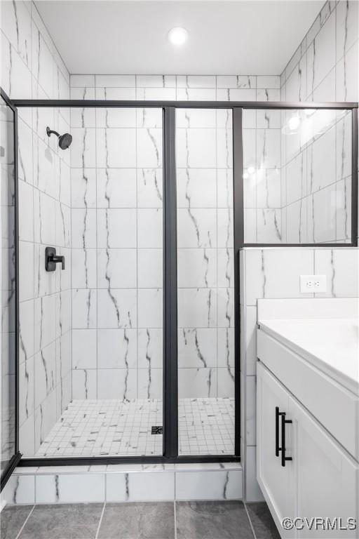 full bath with a stall shower and vanity