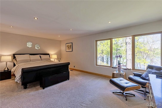 bedroom featuring baseboards, multiple windows, and light carpet