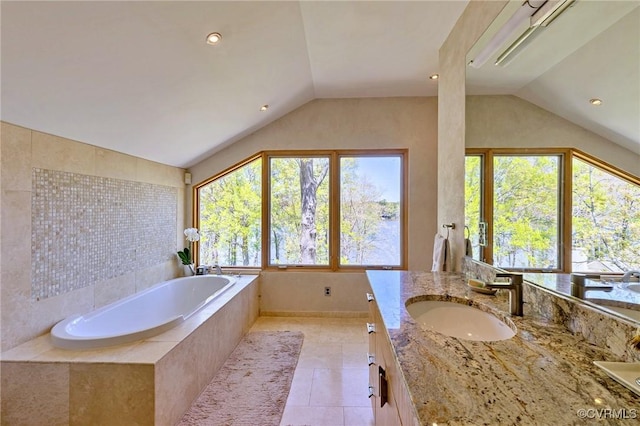 full bath featuring vanity, tile patterned flooring, a garden tub, and vaulted ceiling