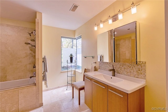 full bath featuring visible vents, tasteful backsplash, tile patterned floors, vanity, and tiled shower / bath combo