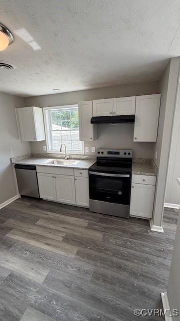 kitchen with white cabinetry, baseboards, appliances with stainless steel finishes, and a sink
