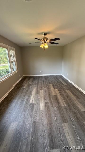 unfurnished room featuring ceiling fan, baseboards, and dark wood-type flooring