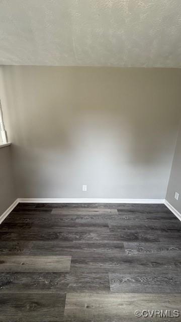 empty room with dark wood-style floors and baseboards