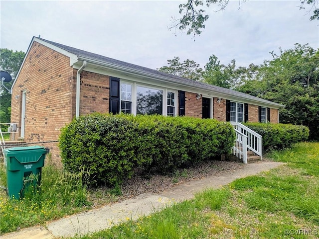 single story home featuring brick siding