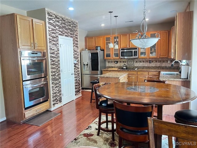 502 Peafowl Ct, Suffolk, VA 23435 - kitchen with stainless steel appliances, a sink, a kitchen island, backsplash, and dark wood finished floors