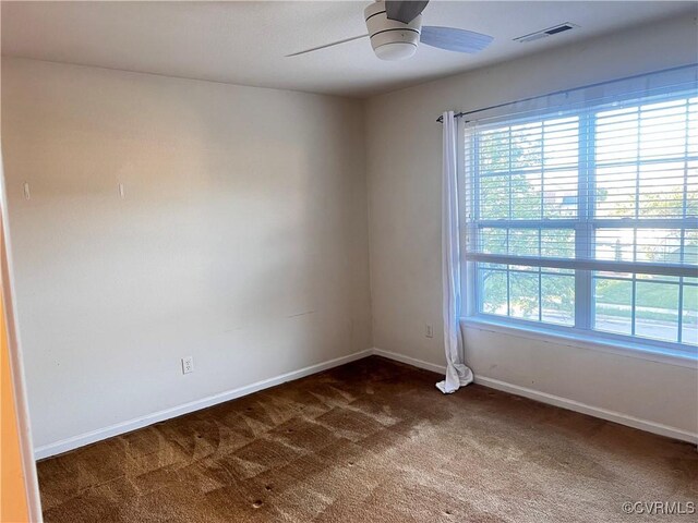 502 Peafowl Ct, Suffolk, VA 23435 - spare room with dark colored carpet, a ceiling fan, and baseboards