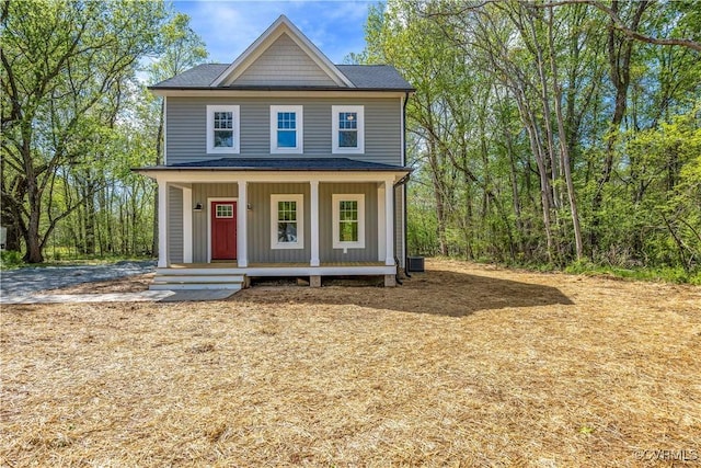 view of front of home featuring a porch, a shingled roof, and central AC