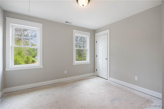 spare room with visible vents, baseboards, and a wealth of natural light