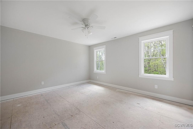 empty room featuring baseboards, a ceiling fan, and visible vents