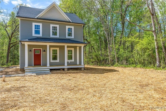 view of front of property featuring a shingled roof and covered porch