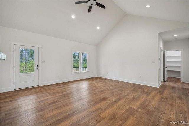 unfurnished living room with high vaulted ceiling, baseboards, hardwood / wood-style floors, and ceiling fan