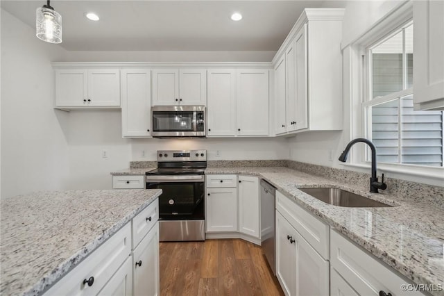 kitchen with stainless steel appliances, white cabinets, dark wood-style flooring, and a sink