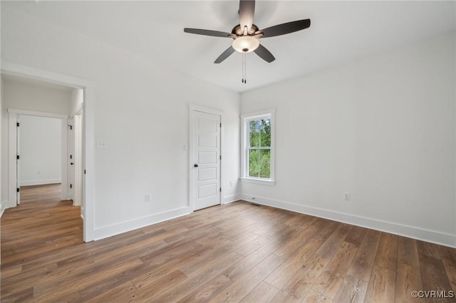 unfurnished bedroom with hardwood / wood-style flooring, baseboards, and a ceiling fan