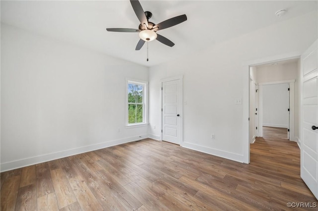 unfurnished bedroom with hardwood / wood-style floors, ceiling fan, and baseboards