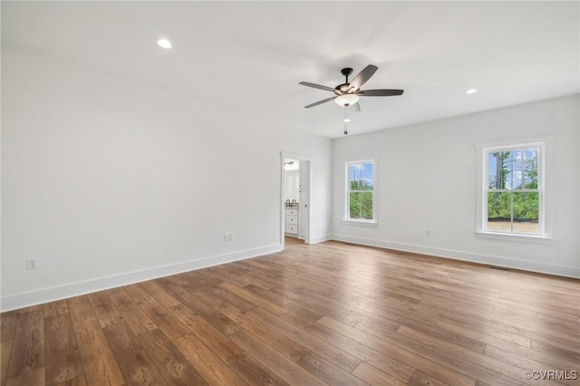unfurnished room featuring hardwood / wood-style floors, a healthy amount of sunlight, baseboards, and a ceiling fan