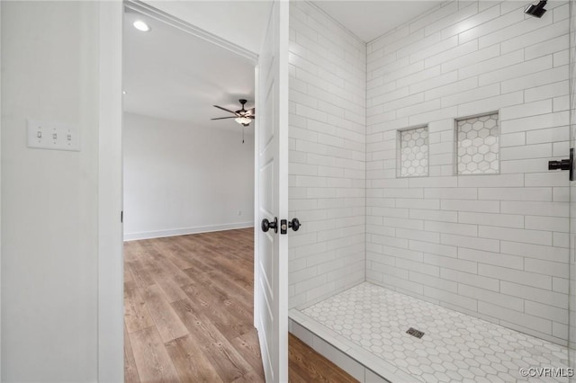 full bath with a tile shower, ceiling fan, recessed lighting, wood finished floors, and baseboards