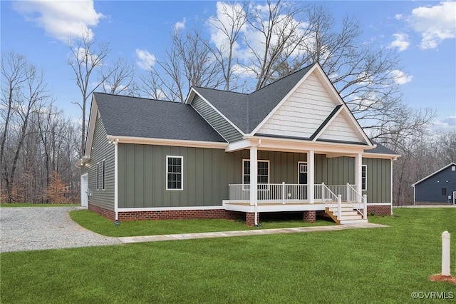 view of front facade featuring board and batten siding, a front lawn, a shingled roof, and covered porch