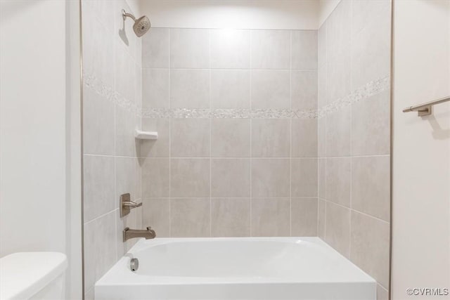 bathroom featuring washtub / shower combination and toilet
